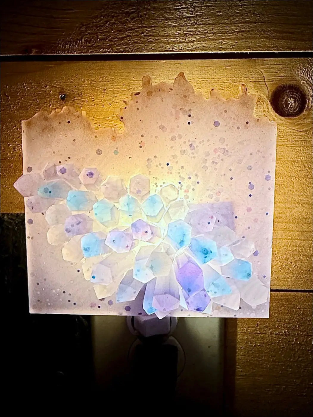 Glowing crystal cluster nightlight with hexagonal design and soft lavender blue gradient on plug-in base wall night light