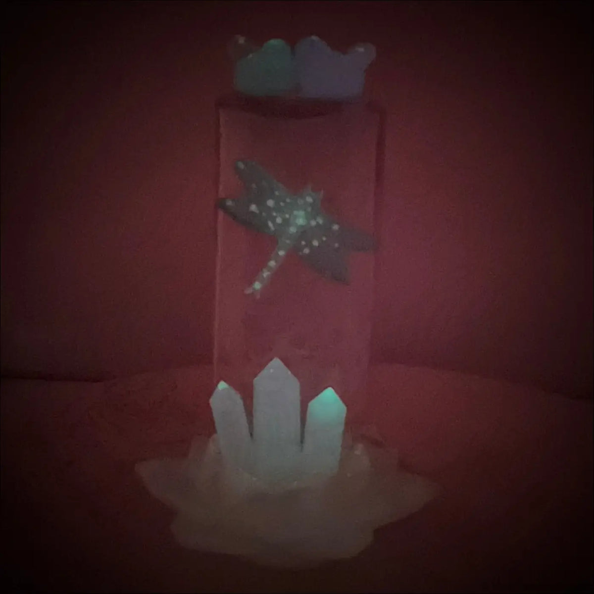 A translucent antique amethyst glass apothecary bottle usb light with a teal dragonfly and white crystal points