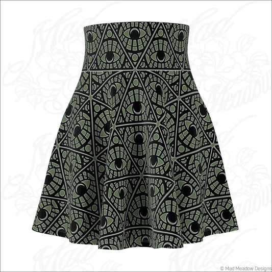 A sage skater skirt with a bold olive green and black mystic eye tribal pattern on stretch fabric with printed care label