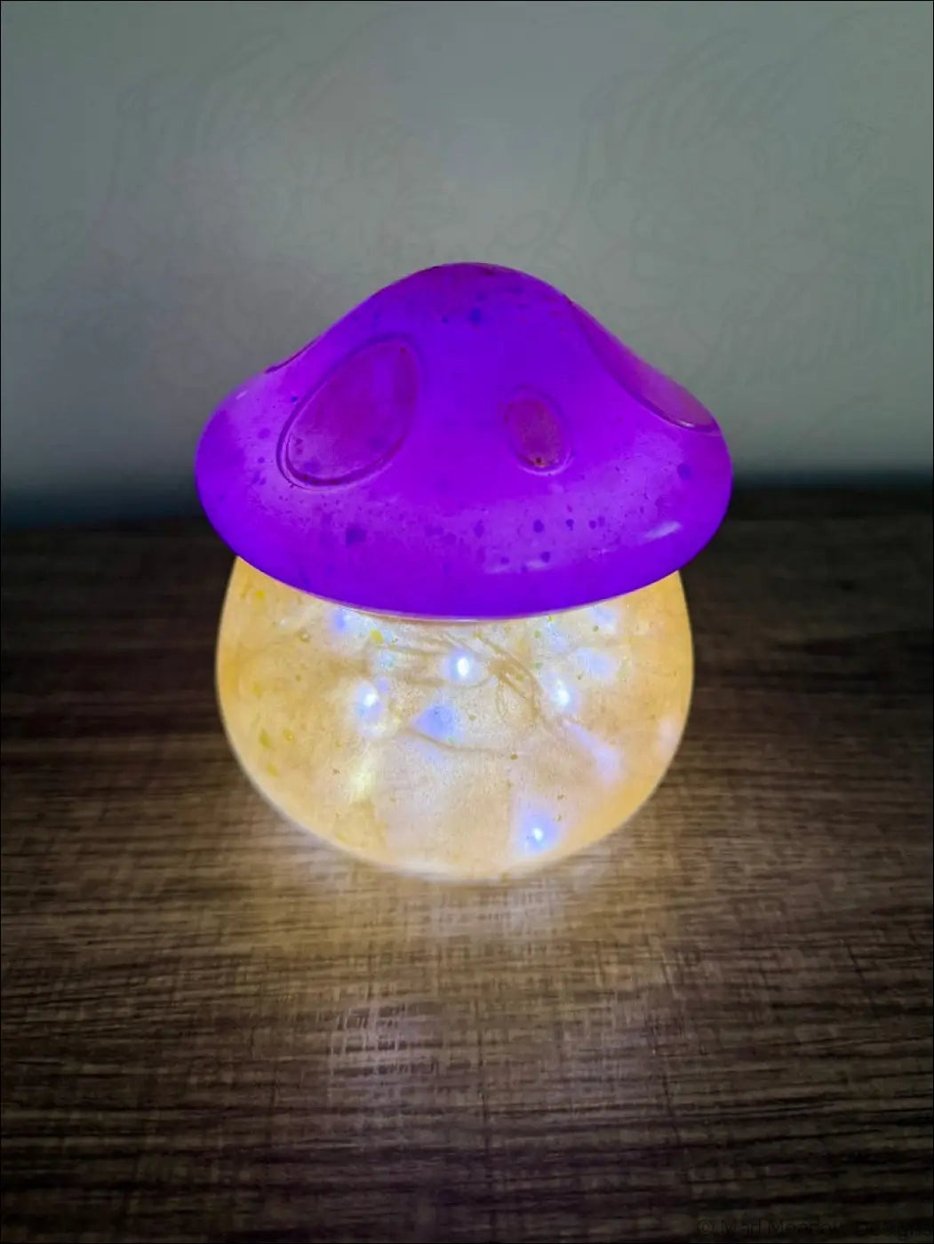Purple and gold chubby mushroom usb light with a purple led cap and translucent yellow base filled with fairy lights