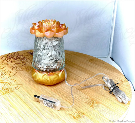 Ornate glass candle holder with golden orange lotus flower top and base featuring etched patterns in red pink and gold resin