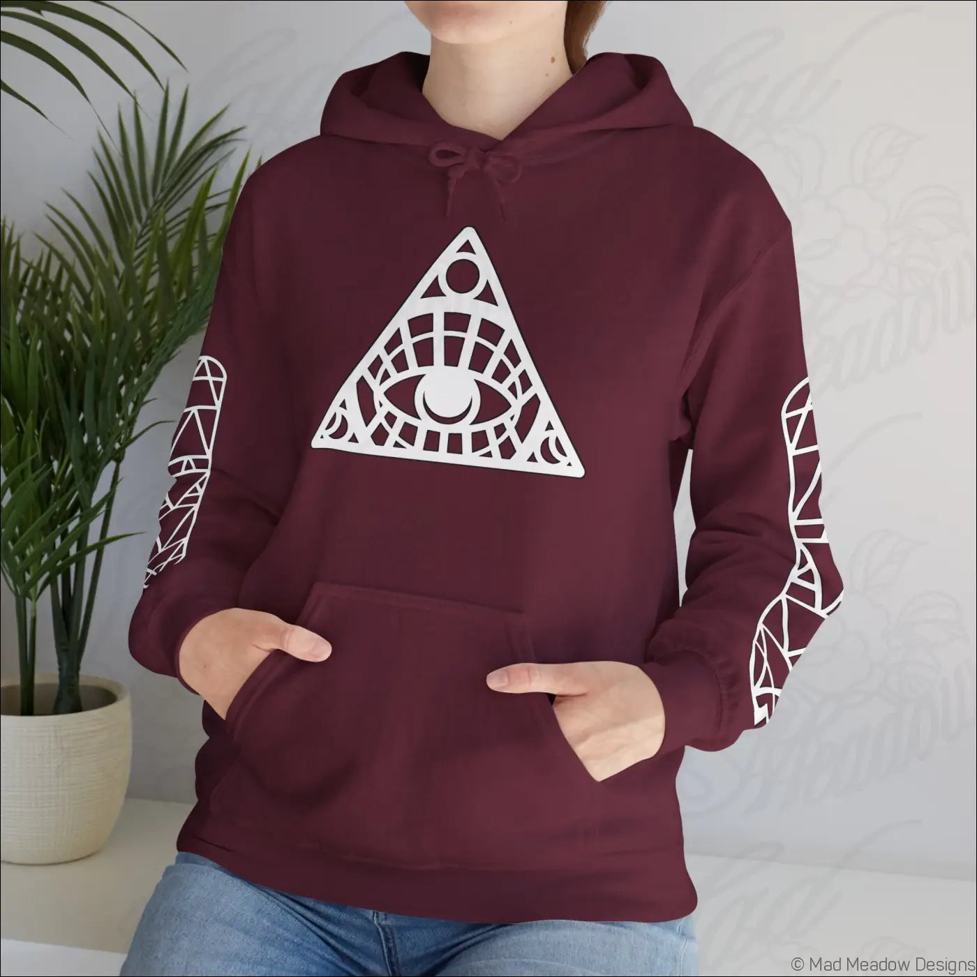 Maroon all-seeing eye triangle hoodie with white geometric design, patterned sleeves, kangaroo pouch, care instructions tumble dry