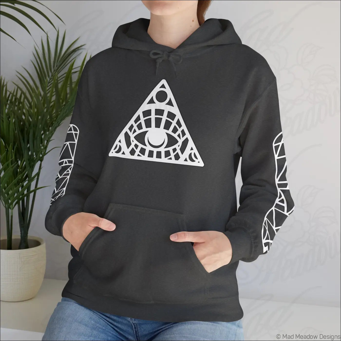 Black hoodie with all-seeing eye triangle design and patterned sleeves featuring kangaroo pouch and care instructions to tumble dry