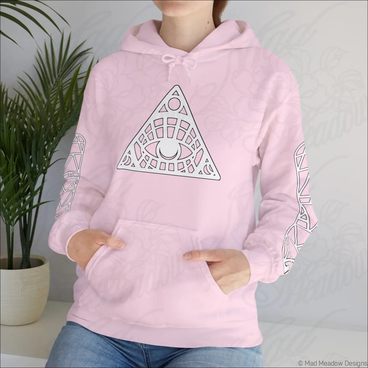 Soft pink all-seeing eye triangle hoodie with white geometric design and kangaroo pouch tumble dry friendly care instructions