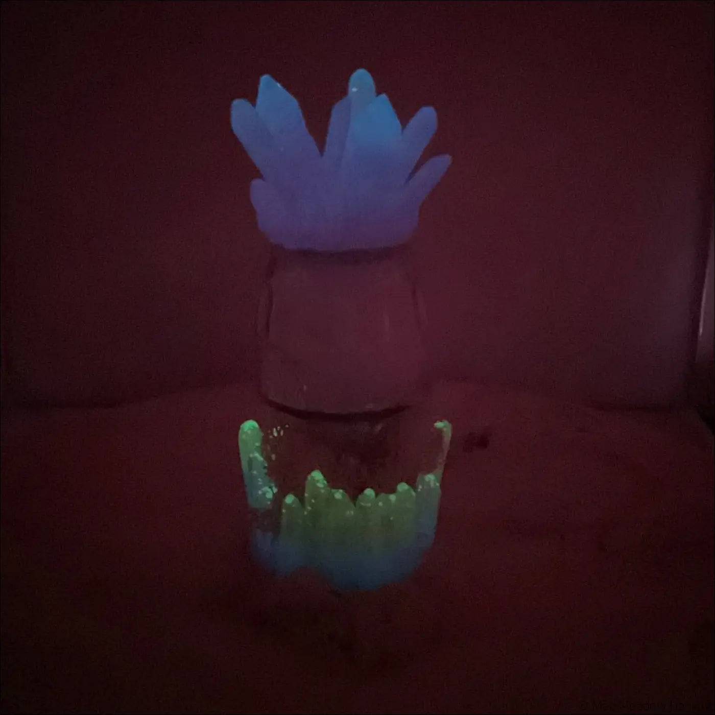 A glowing translucent usb light figurine with a crown of blue purple crystals and a greenish blue base