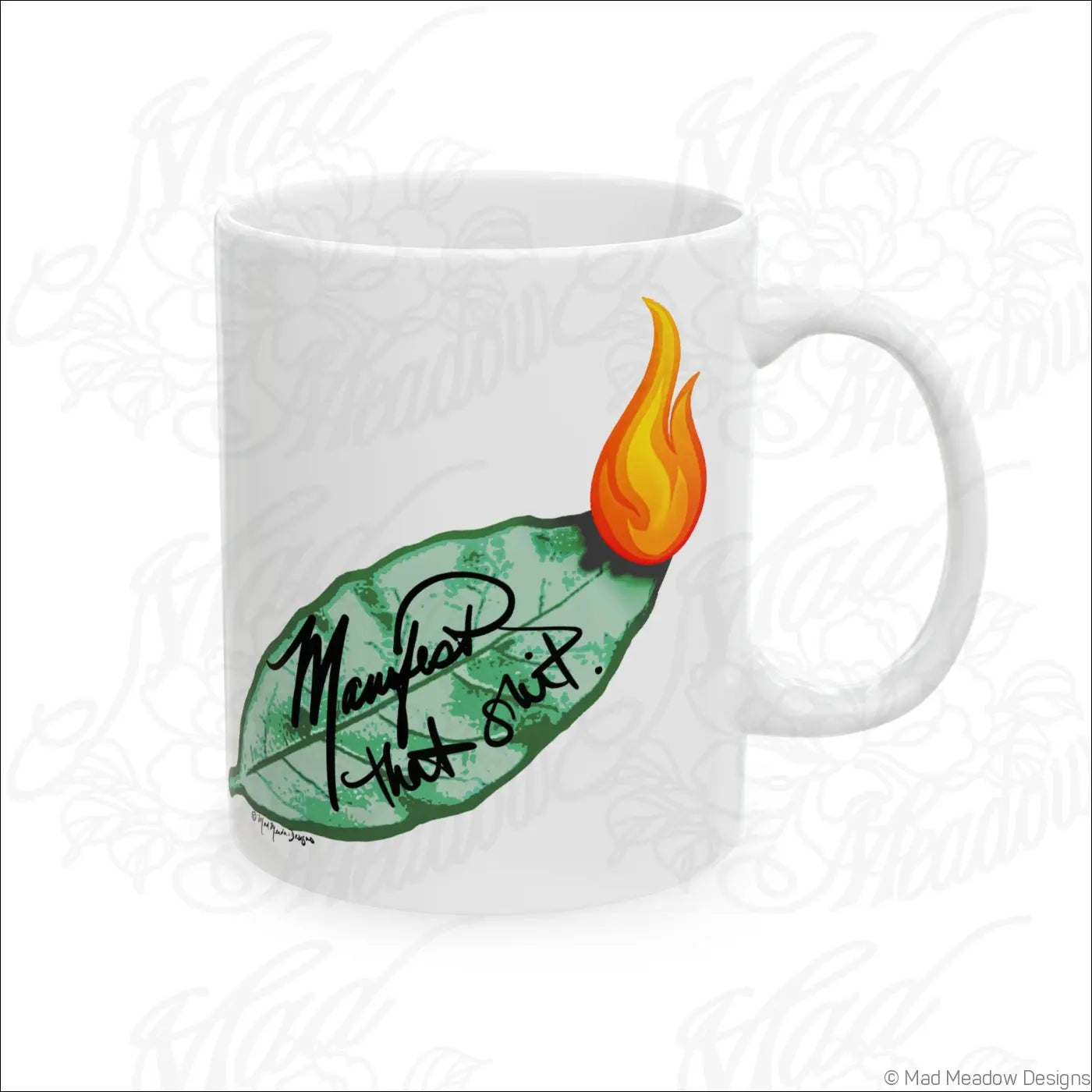 Glossy white ceramic mug with comfortable c-handle featuring hand-drawn green leaf orange flame and manifest that shit text