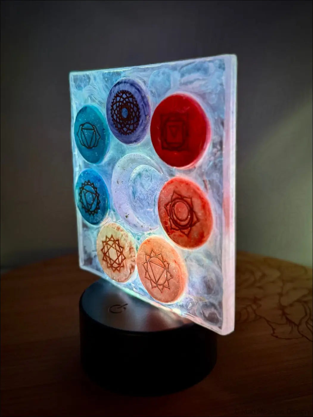 Translucent chakra night light with rainbow-colored disks and a glowing crescent moon in frosted glass panel