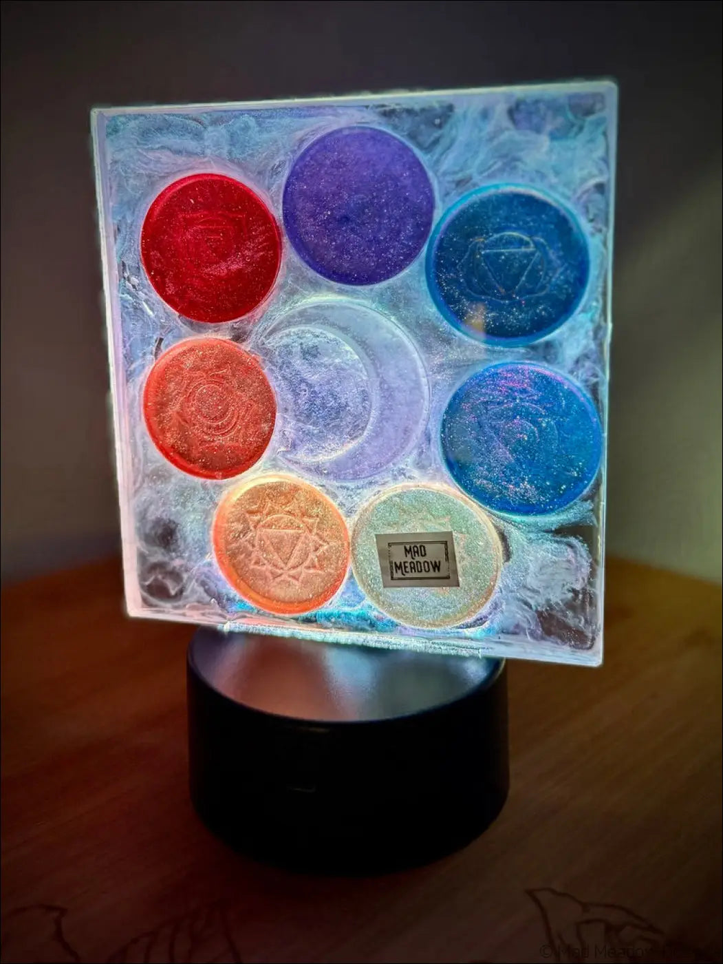 A square translucent glass chakra night light with rainbow-colored disks and a glowing crescent moon design