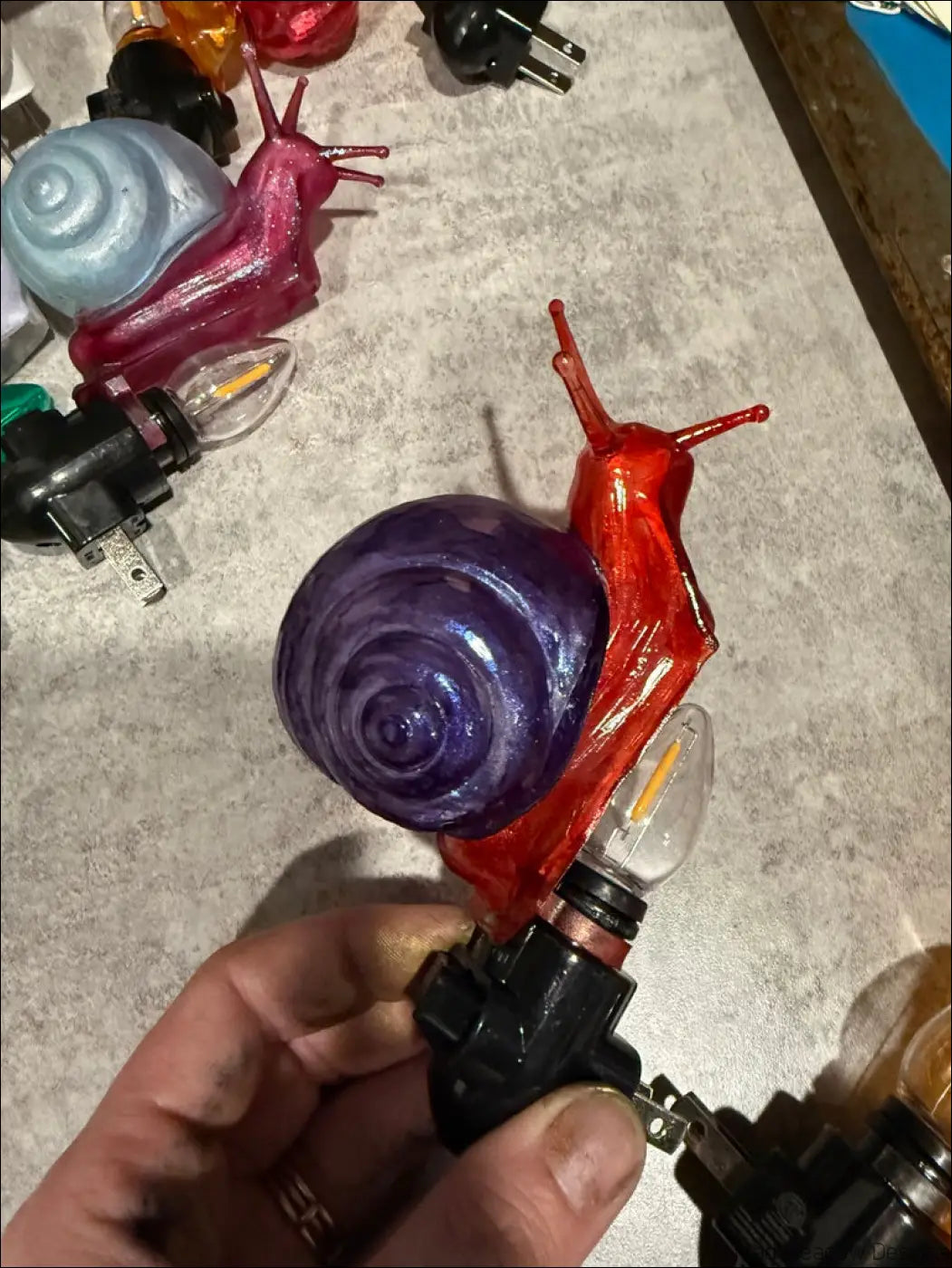Charming snail night light with a translucent red glass body and vibrant purple hues perfect for a whimsical wonderland