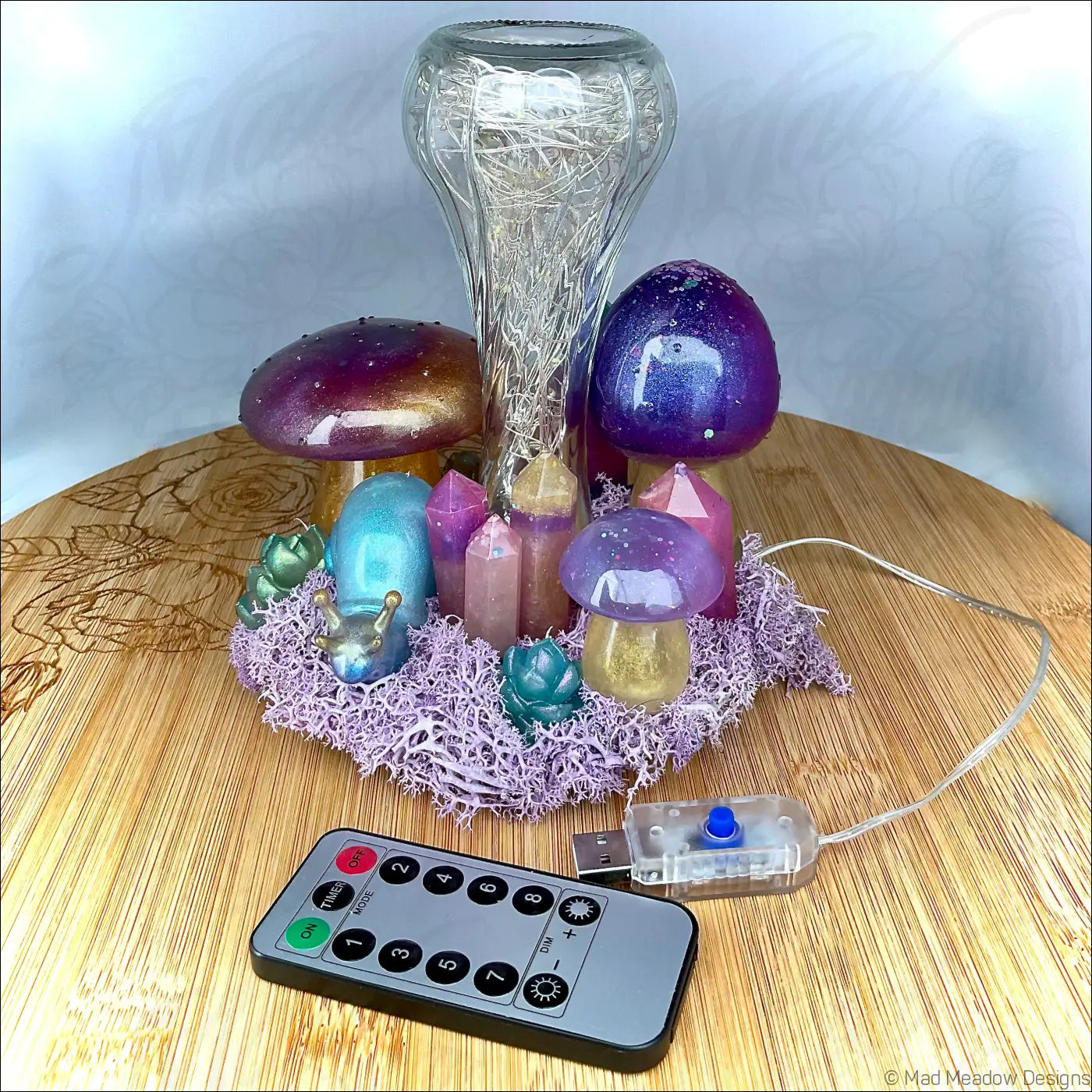 A colorful fairycore tabletop light with handcrafted resin mushrooms snail companion crystals and a clear glass vase
