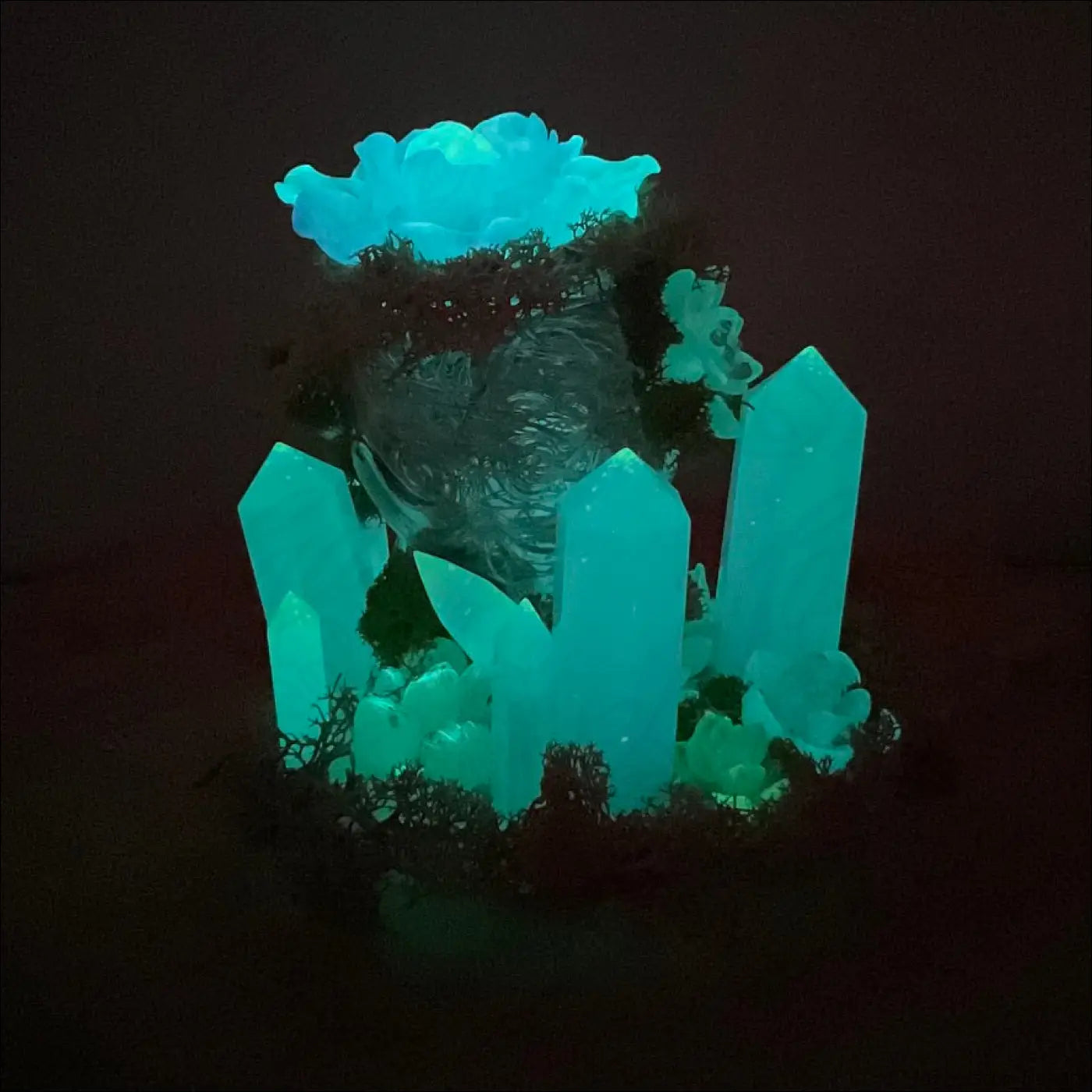Glowing teal crystal centerpiece with translucent skull and moss on a vintage glass bottle usb powered garden light