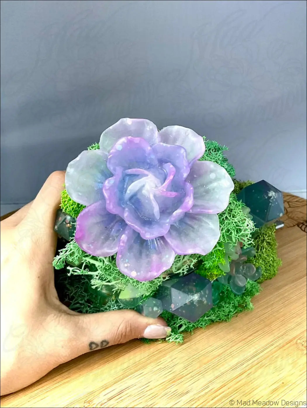A usb powered vintage glass bottle features a translucent purple resin flower with moss and dark geometric crystals