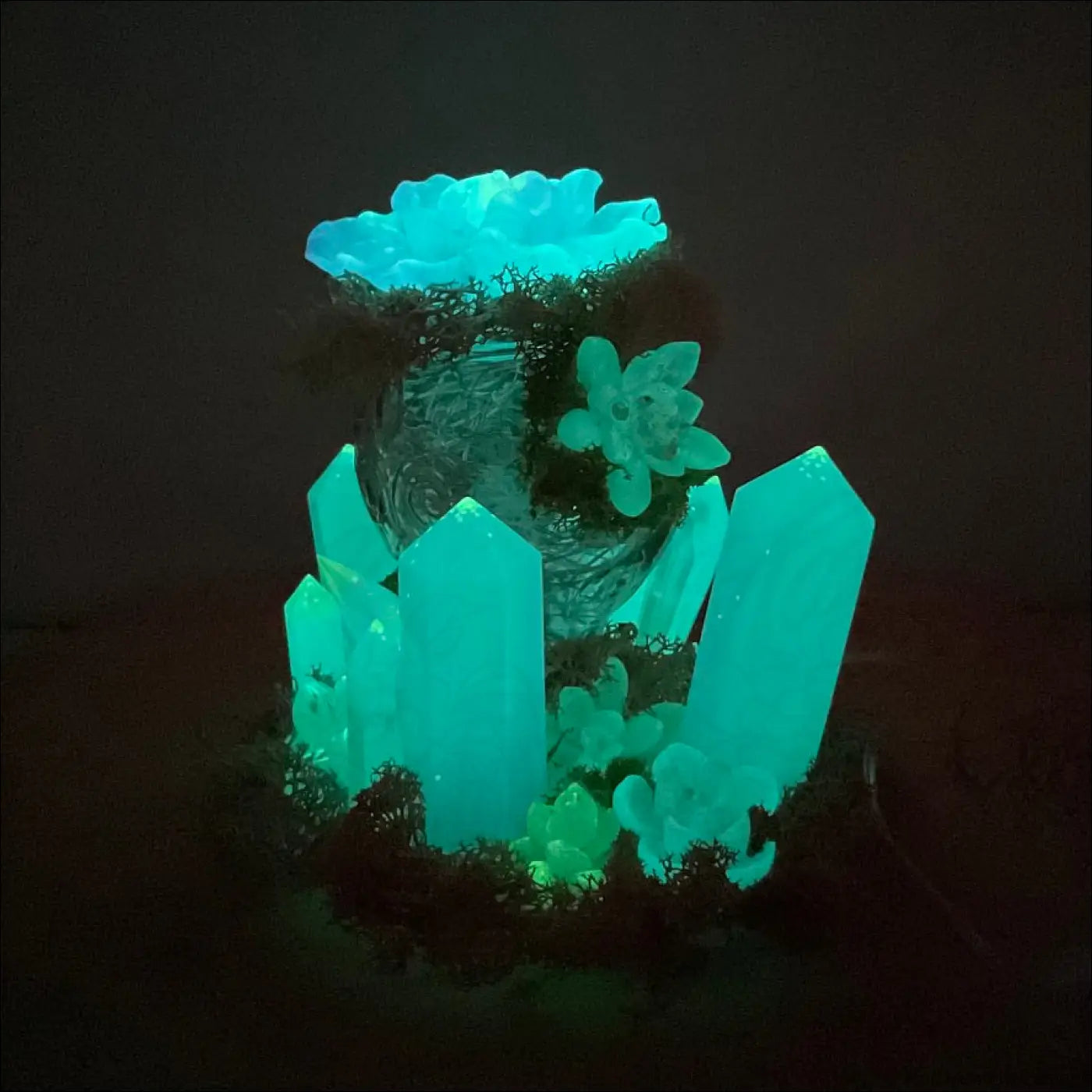 Glowing teal crystal centerpiece with succulent accents on a moss base in usb powered vintage glass garden light