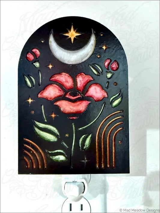 Black arched night light with elegant pink flowers green leaves and celestial moon and star motifs in bohemian style