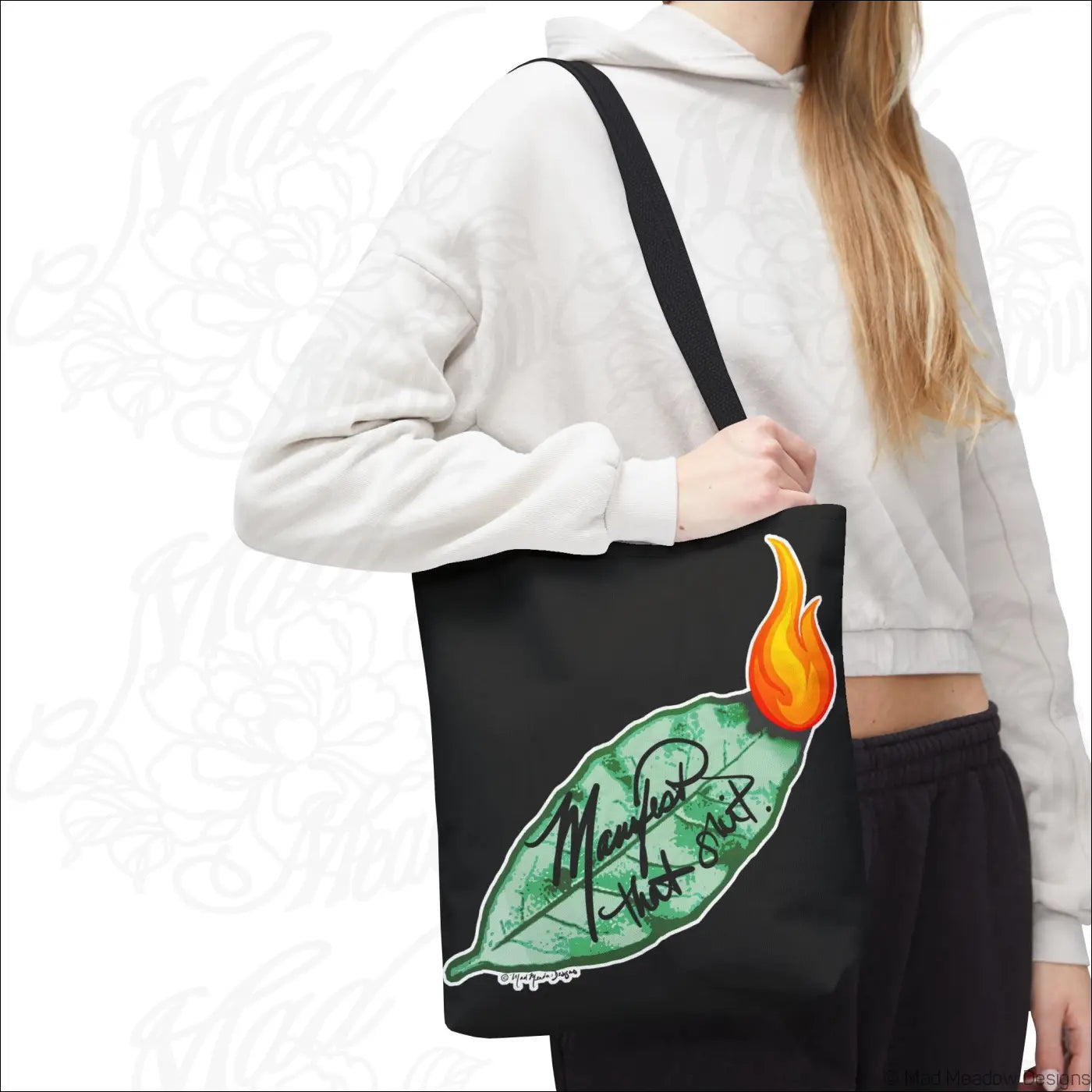 Black canvas flaming bay leaf tote bag with boxed corners and care instructions featuring green leaf and orange flame design