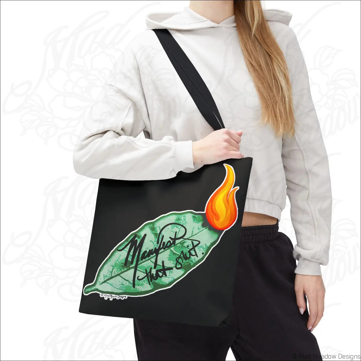 Black canvas flaming bay leaf tote bag with boxed corners and care instructions featuring manifest that shit text