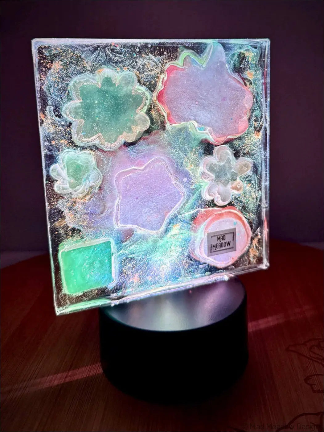 A square translucent resin pastel garden nightlight with glowing flower cutouts and swirling galaxy background