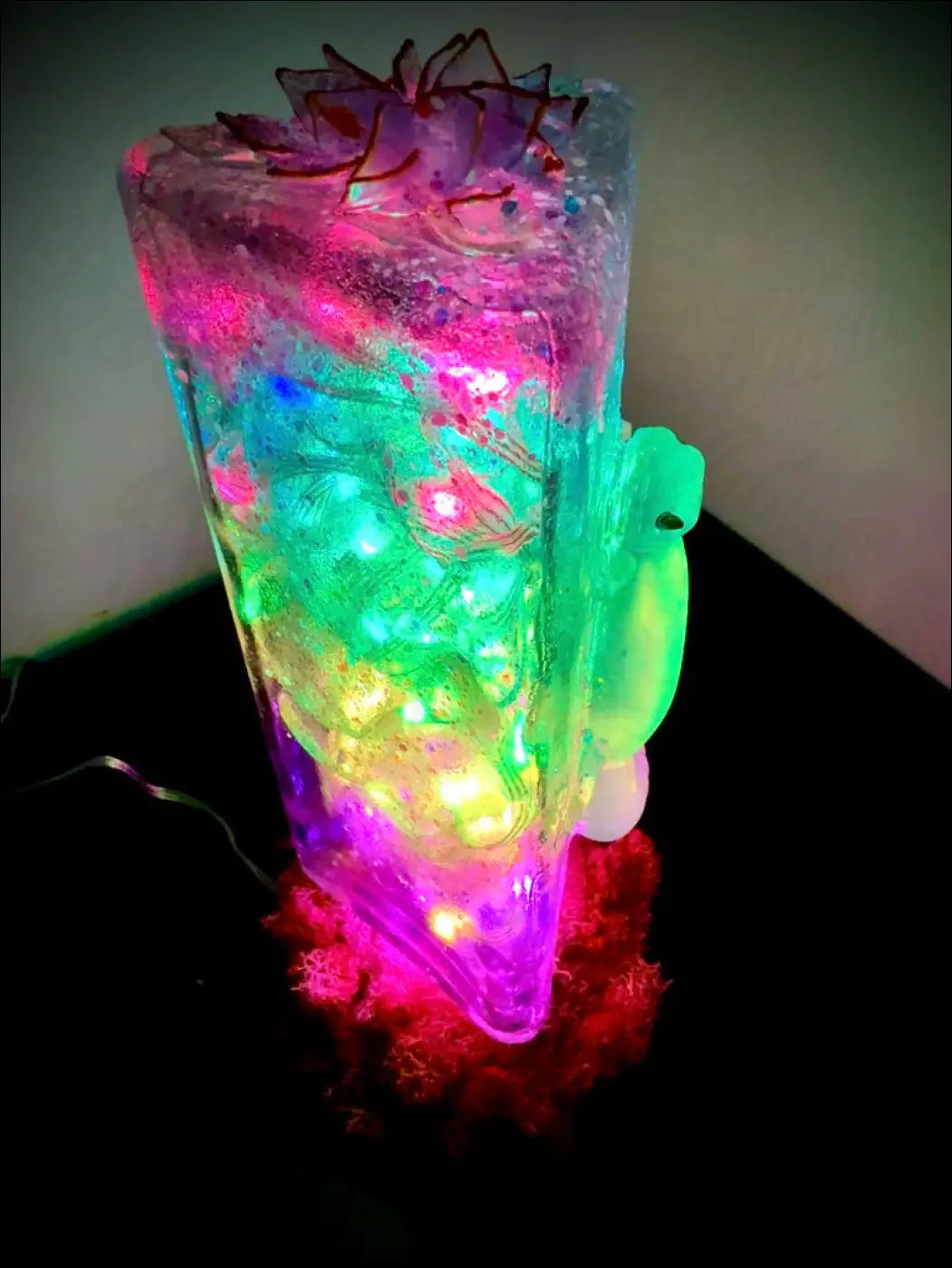 A translucent multi-colored led light sculpture shaped like a cake slice with glowing lights in gecko and lotus usb light