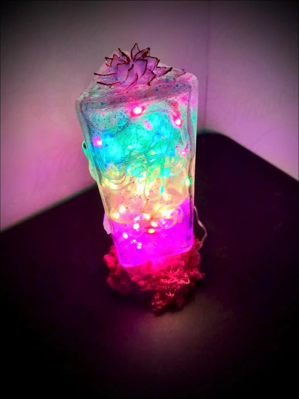A translucent rectangular resin usb lamp with glowing fairy lights and a lotus flower design called gecko and lotus