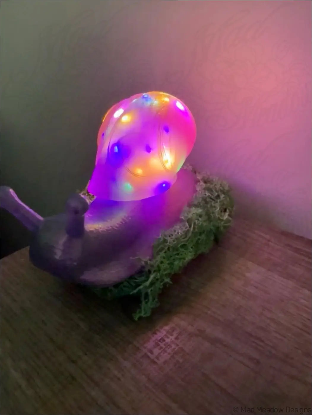 A glowing translucent led snail lamp with a colorful shell, purple body, and green moss light usb color change