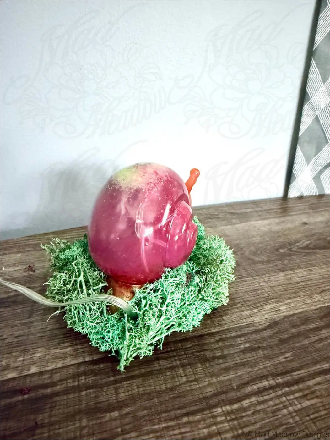 A translucent pink giant snail figurine with gold antennae resting on green moss rgb usb battery light