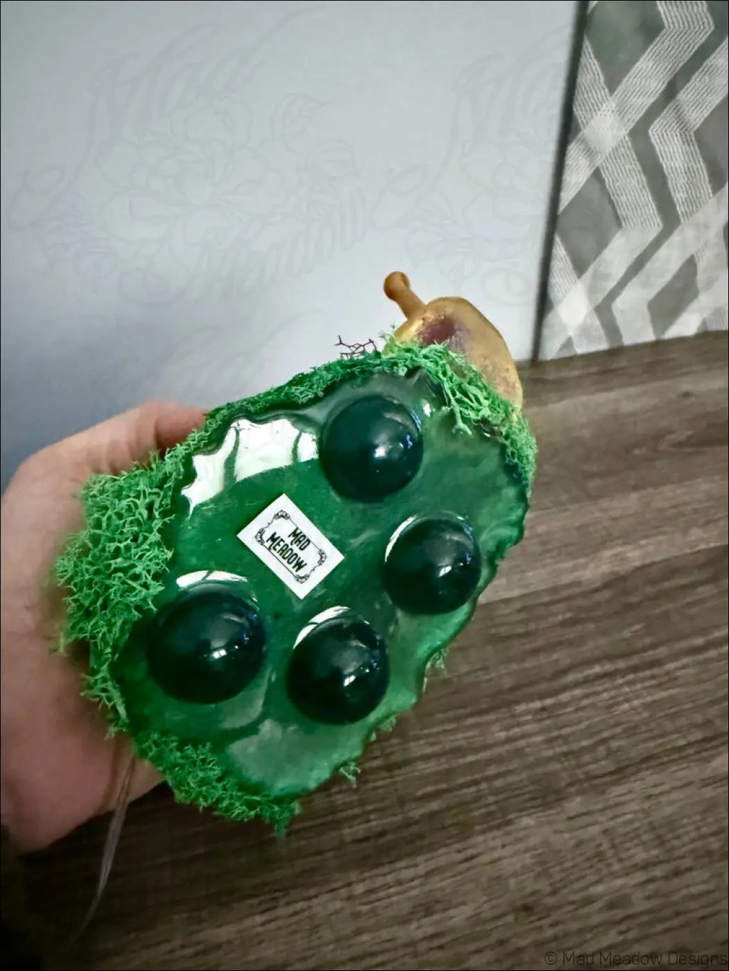 Green glass grape-shaped ornament with black spheres and mossy base for giant purple and gold snail usb light