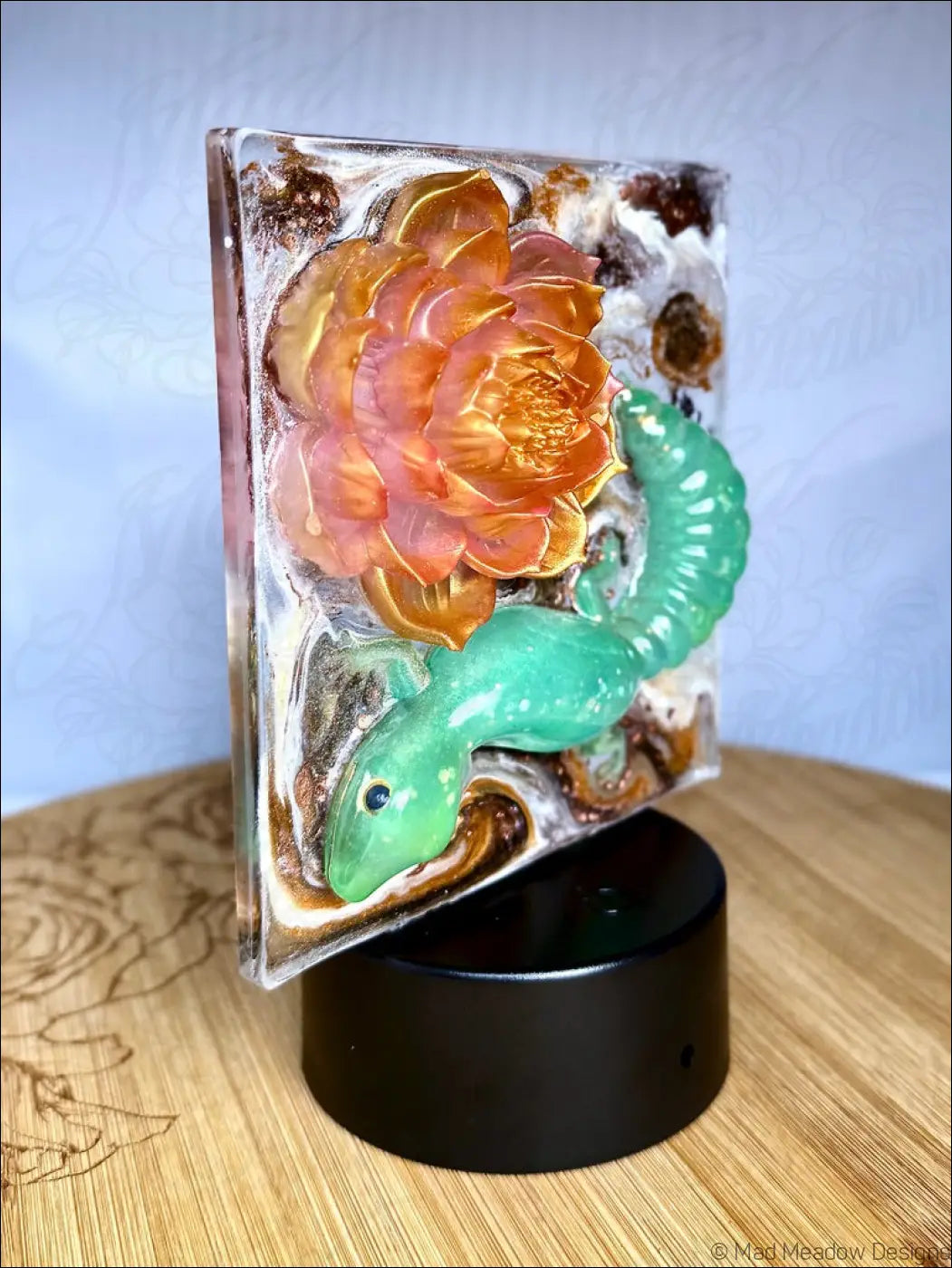 Translucent resin glowing gecko night light with pink lotus and shimmering gold accents in orange pink hues