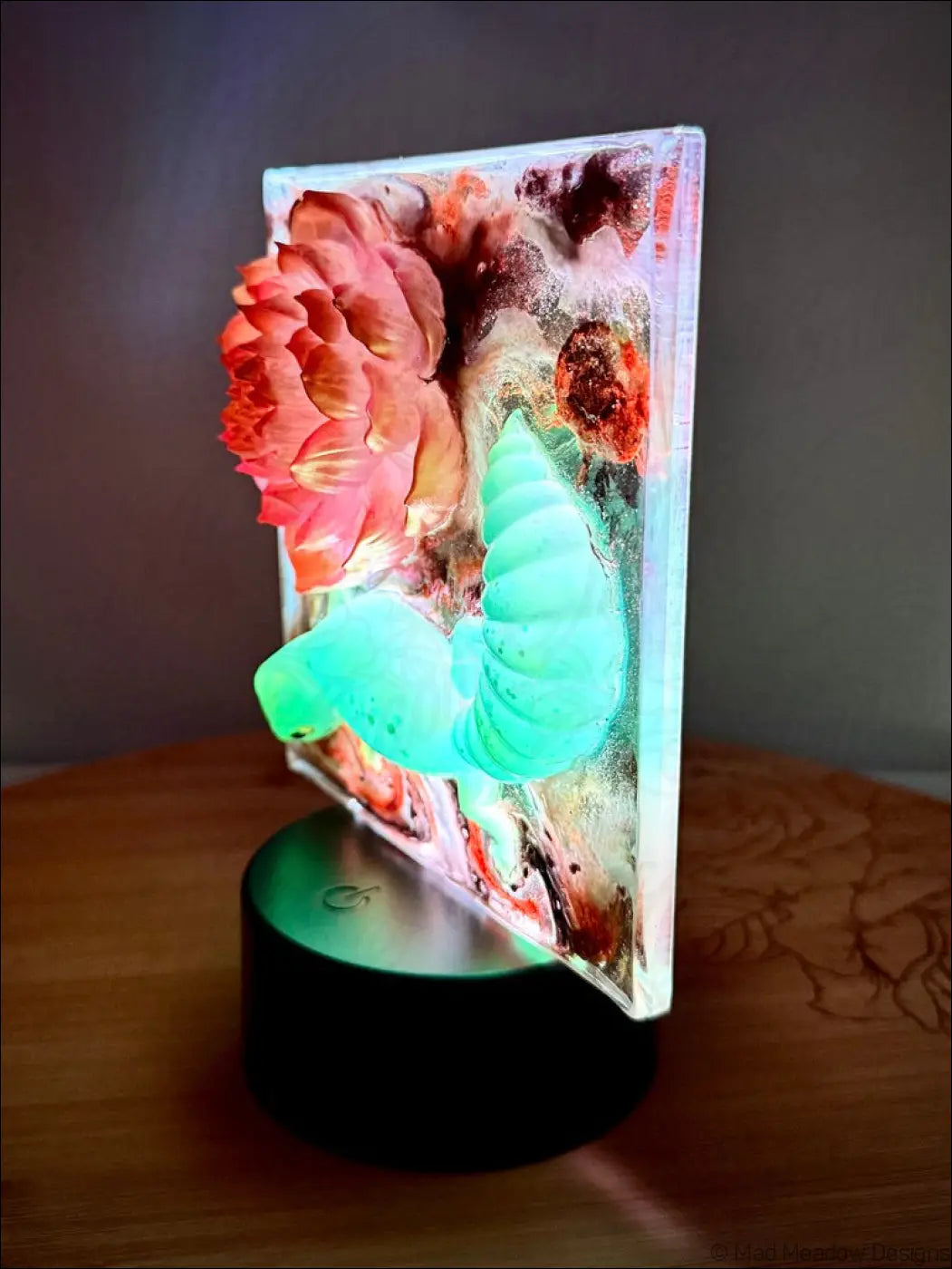 A glowing resin pink lotus nightlight with an enchanting glowing gecko and shimmering gold accents and glitter