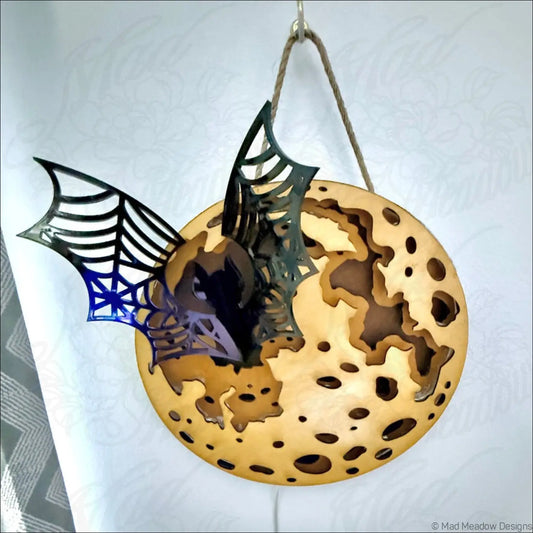Glowing golden moon and bat hanging wall light with enchanting laser-cut wood design and natural wood tones