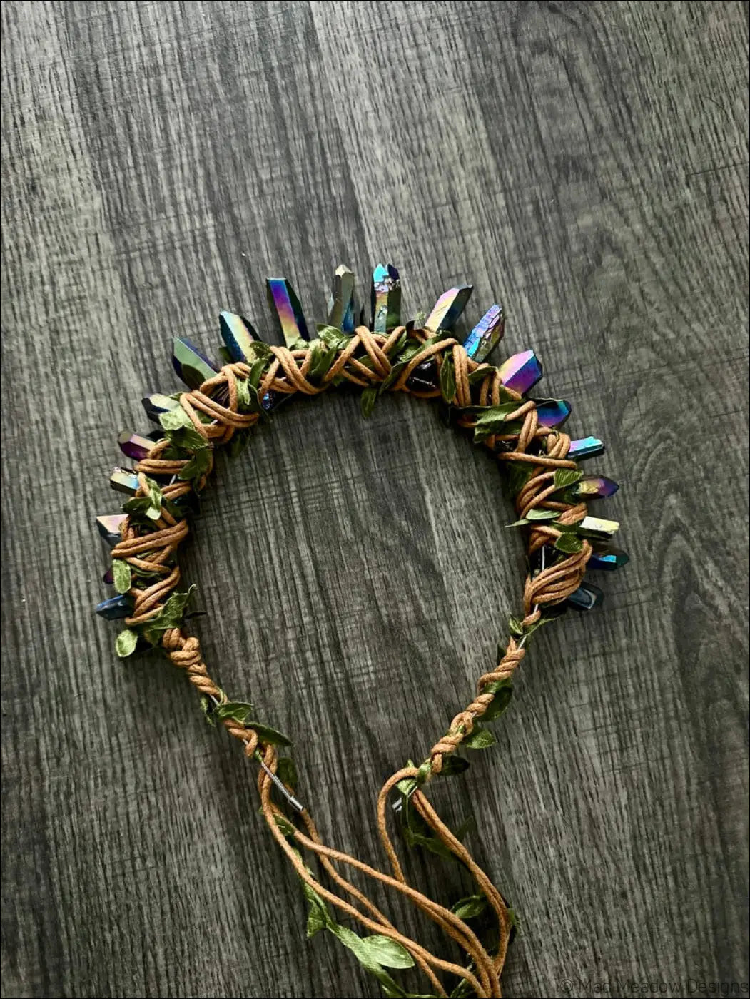 Handcrafted dark golden goddess crown with iridescent crystal points woven green leaves and braided tan leather