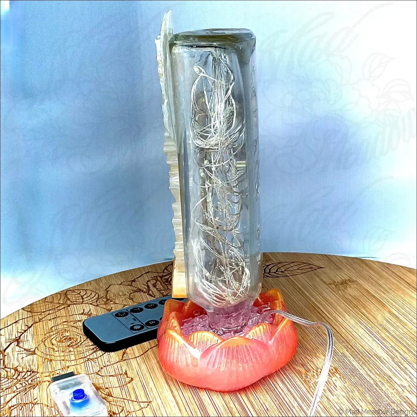 Clear glass cylindrical antique glass apothecary bottle with led lights on red-orange lotus flower base usb light