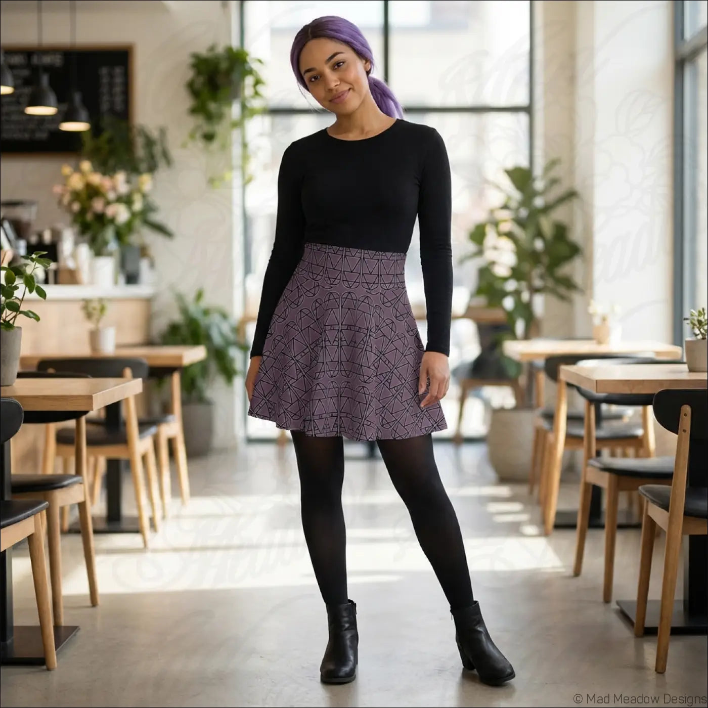 A flared purple grape elemental column pattern skater skirt worn over black leggings with a black top care instructions line dry