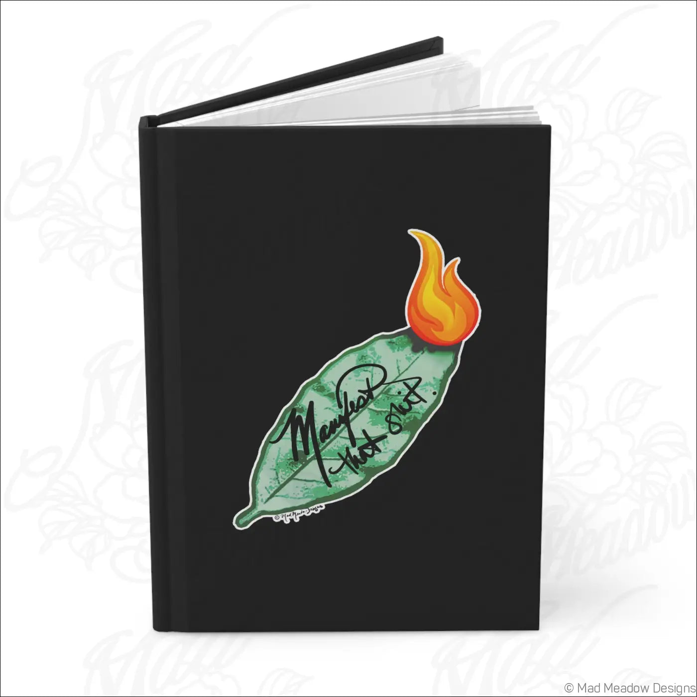 Black hardcover journal with matte laminated cover featuring green bay leaf and orange flame with mentor that burnt text