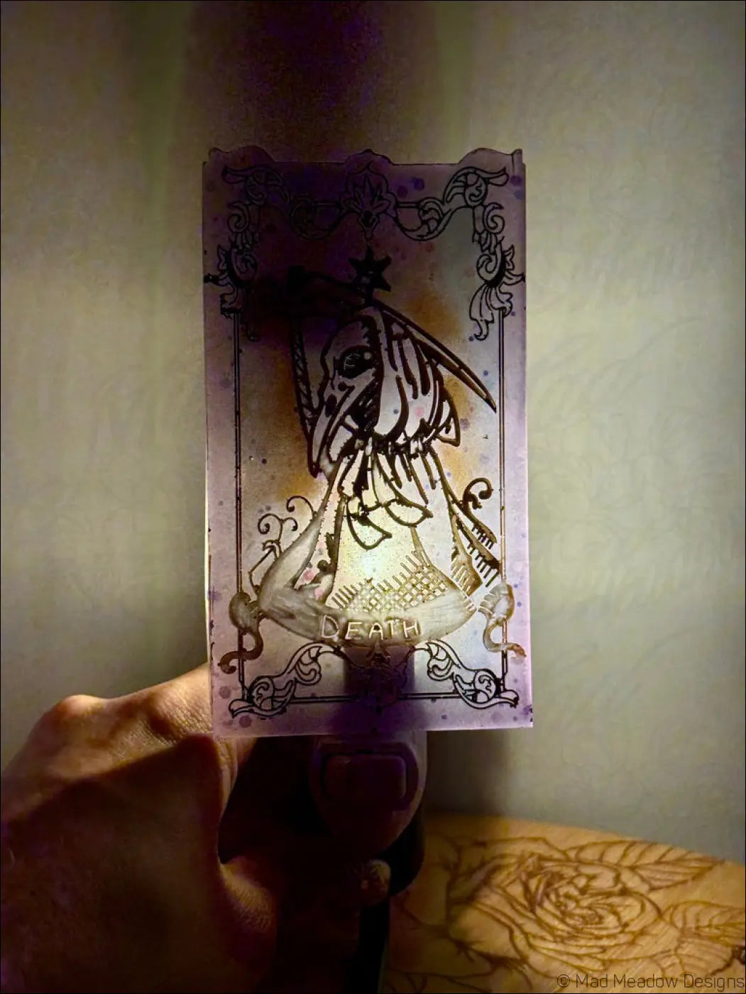 Iridescent death tarot wall night light in translucent pastel purple resin with black ornate borders and skeletal figure