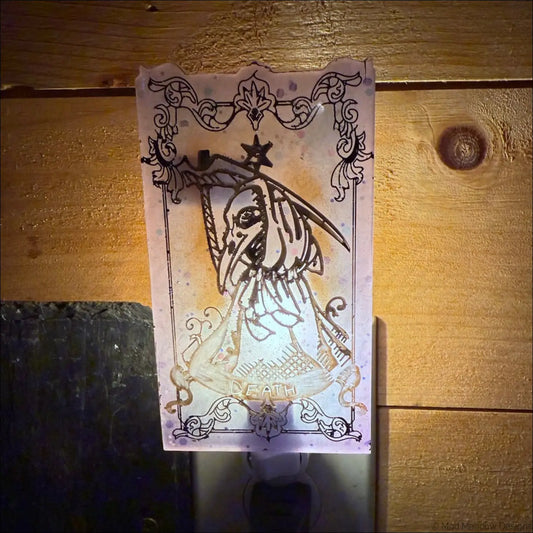 Iridescent death tarot wall night light in pale pink resin with black ink death card and gold accents on plug-in base