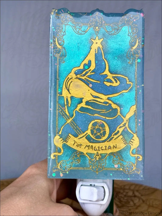 Teal and gold resin tarot night light shaped like the magician card with intricate detailing on plug-in base for tarot resin wall use