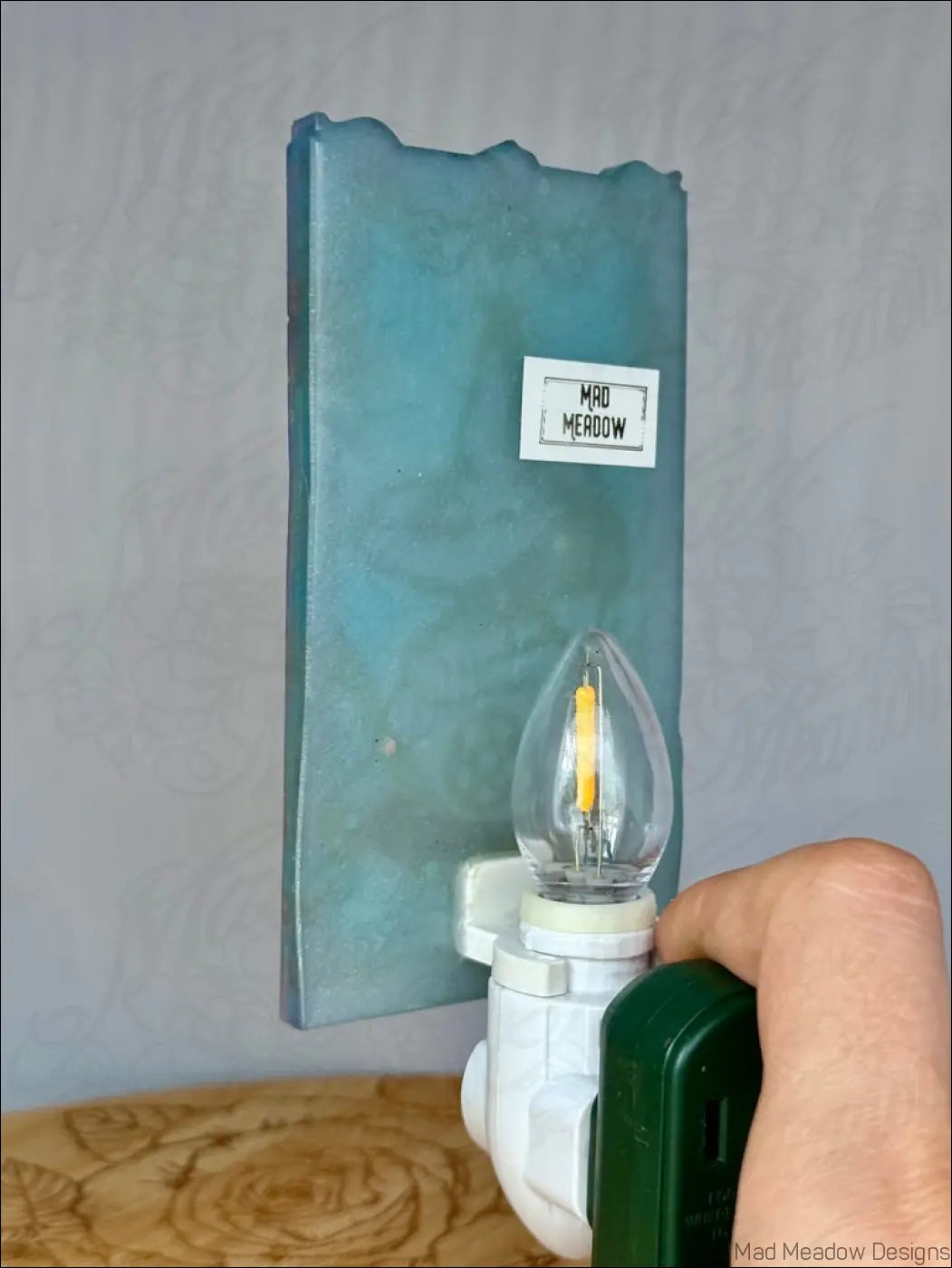 Teal textured resin wall night light with clear bulb on white plug-in base featuring mesmerizing magician tarot design
