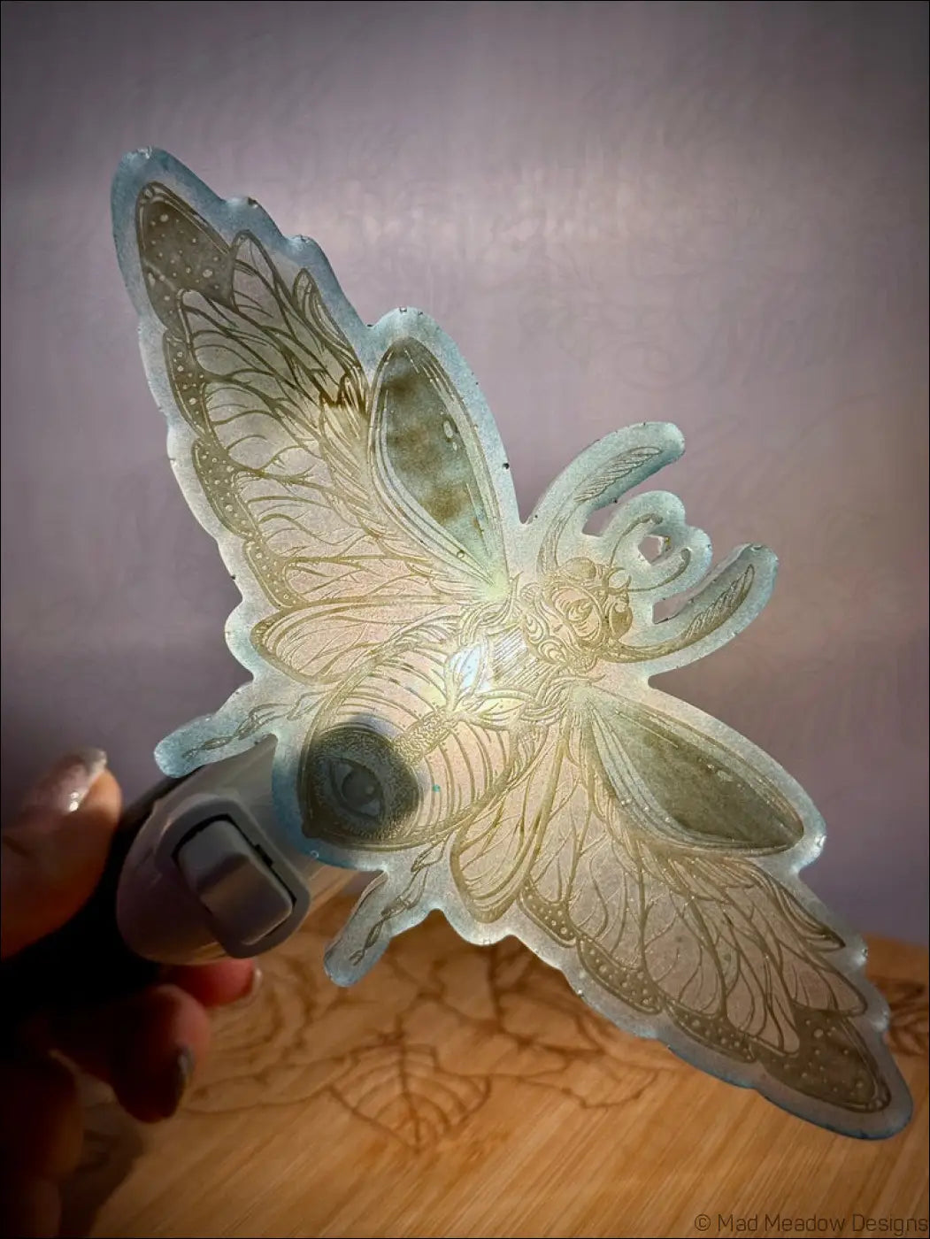 A translucent light green resin wall night light shaped like a stunning iridescent scarab with golden detailing