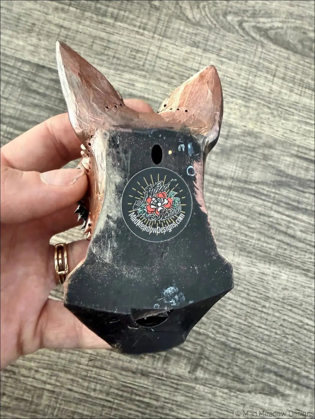 A handcrafted copper-colored red fox wall sculpture with natural labradorite eyes on a black base