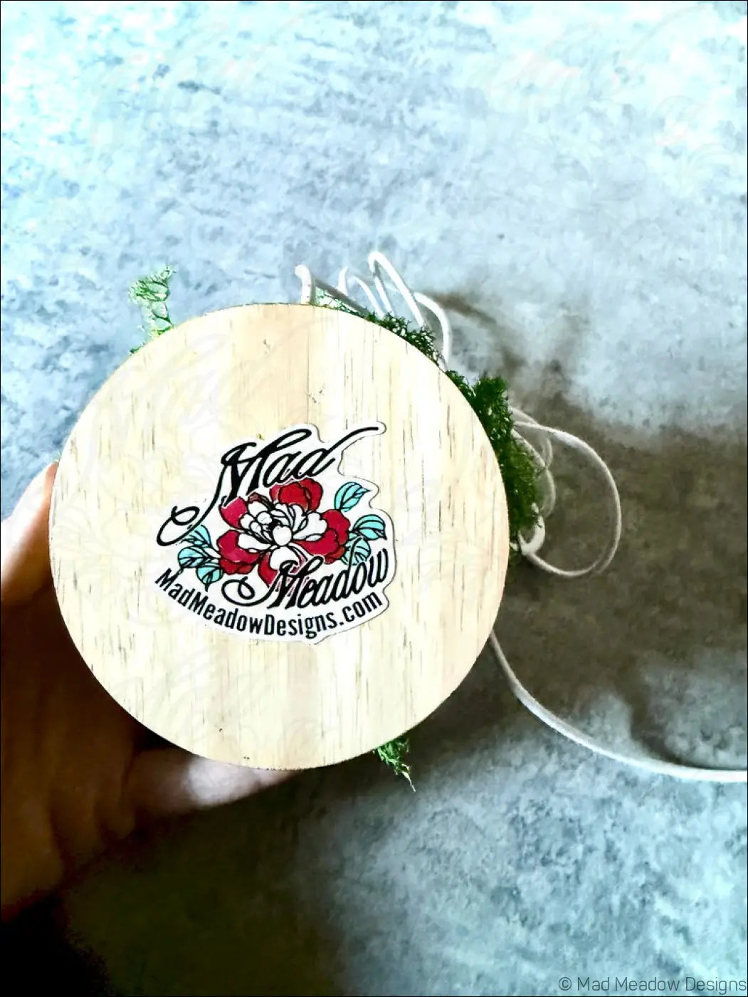 Light wooden circular lid with mad meadow logo on large resin crystal cluster glow in the dark wooden base