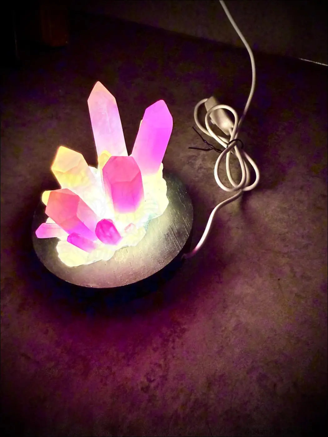 Large resin crystal cluster glow in the dark lamp with glowing pink and purple resin crystal facets on a wooden base