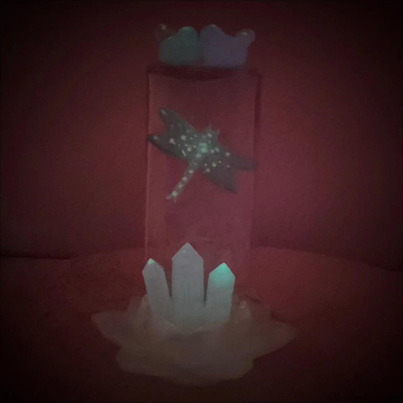 A translucent antique amethyst glass apothecary bottle usb light with a teal dragonfly and white crystal points