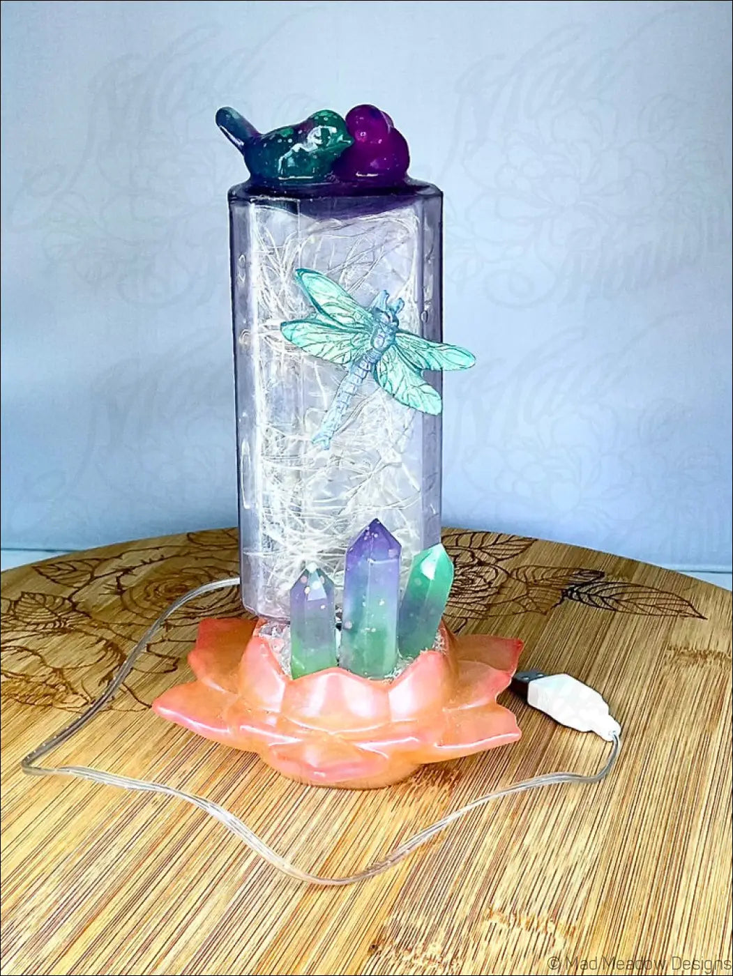 Translucent purple usb light on antique amethyst glass apothecary bottle with fairy lights bird flower and crystals