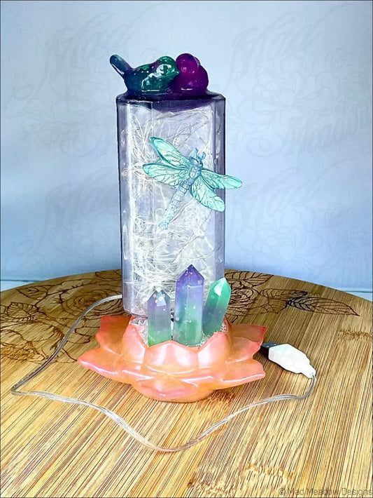 Translucent purple usb light on antique amethyst glass apothecary bottle with fairy lights bird flower and crystals