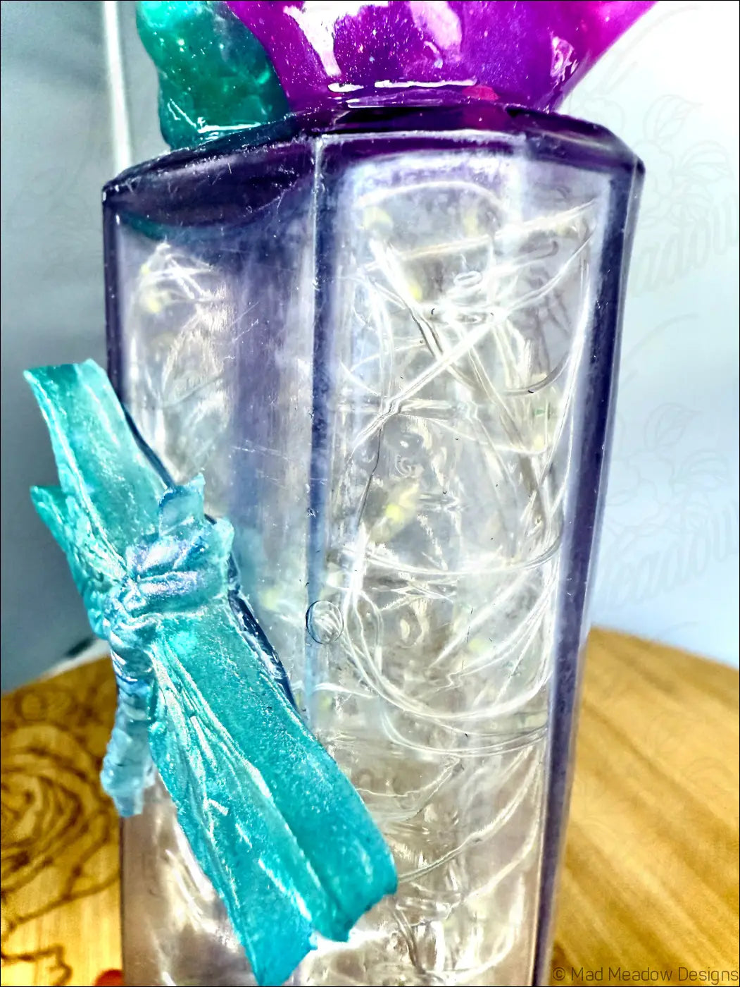 Translucent purple antique amethyst glass apothecary bottle with teal resin dragon and tangled fairy lights inside