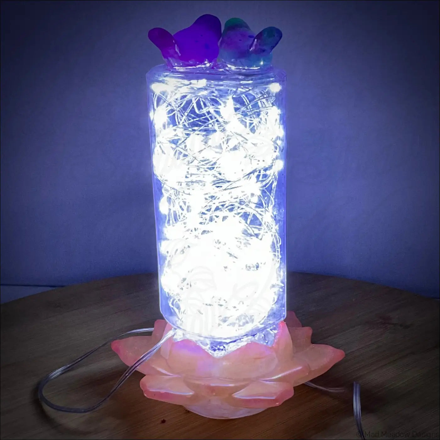 Translucent cylindrical usb lamp with glowing fairy lights on an antique amethyst glass apothecary bottle base