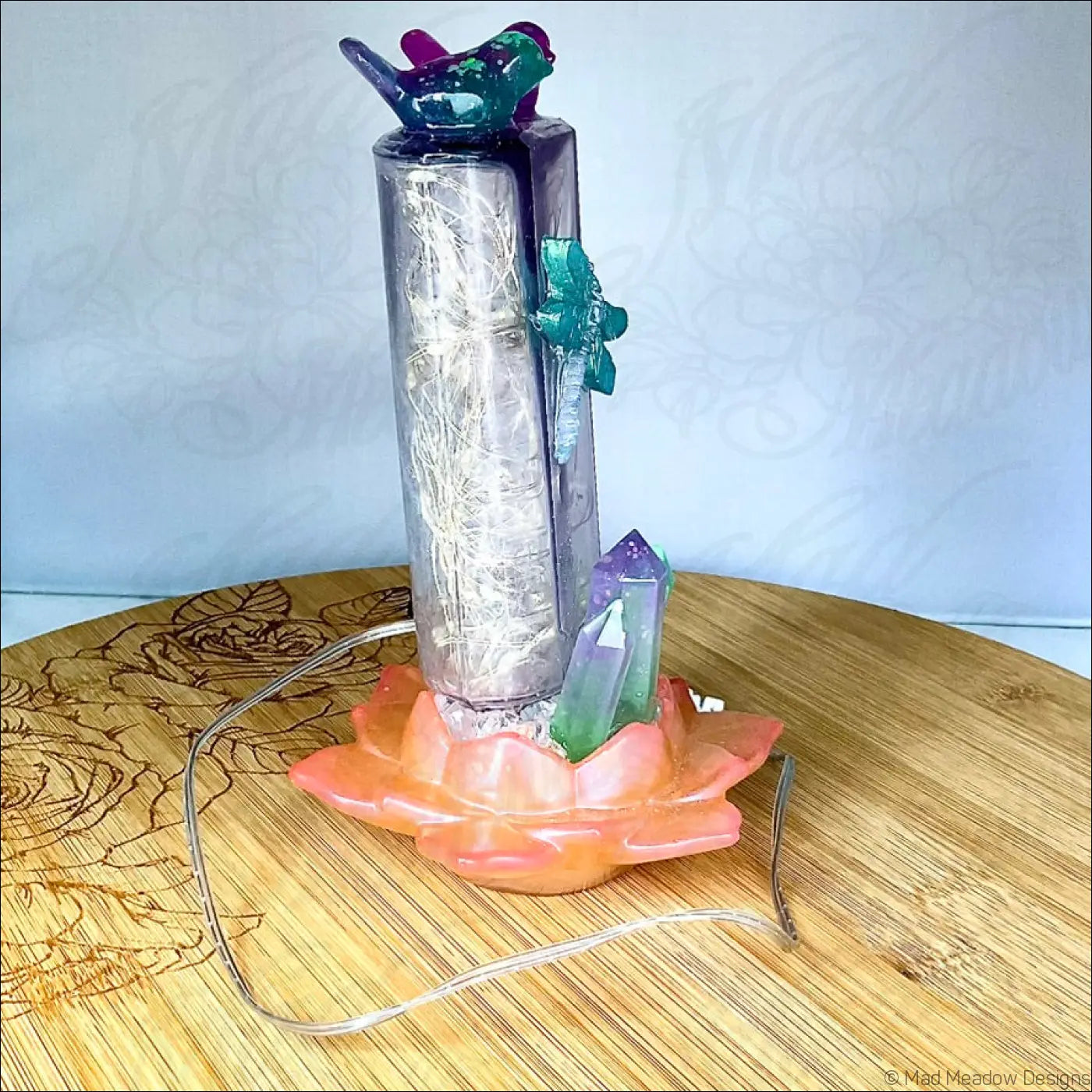 Translucent purple resin love birds centerpiece with colorful bird and crystals on antique amethyst glass apothecary bottle