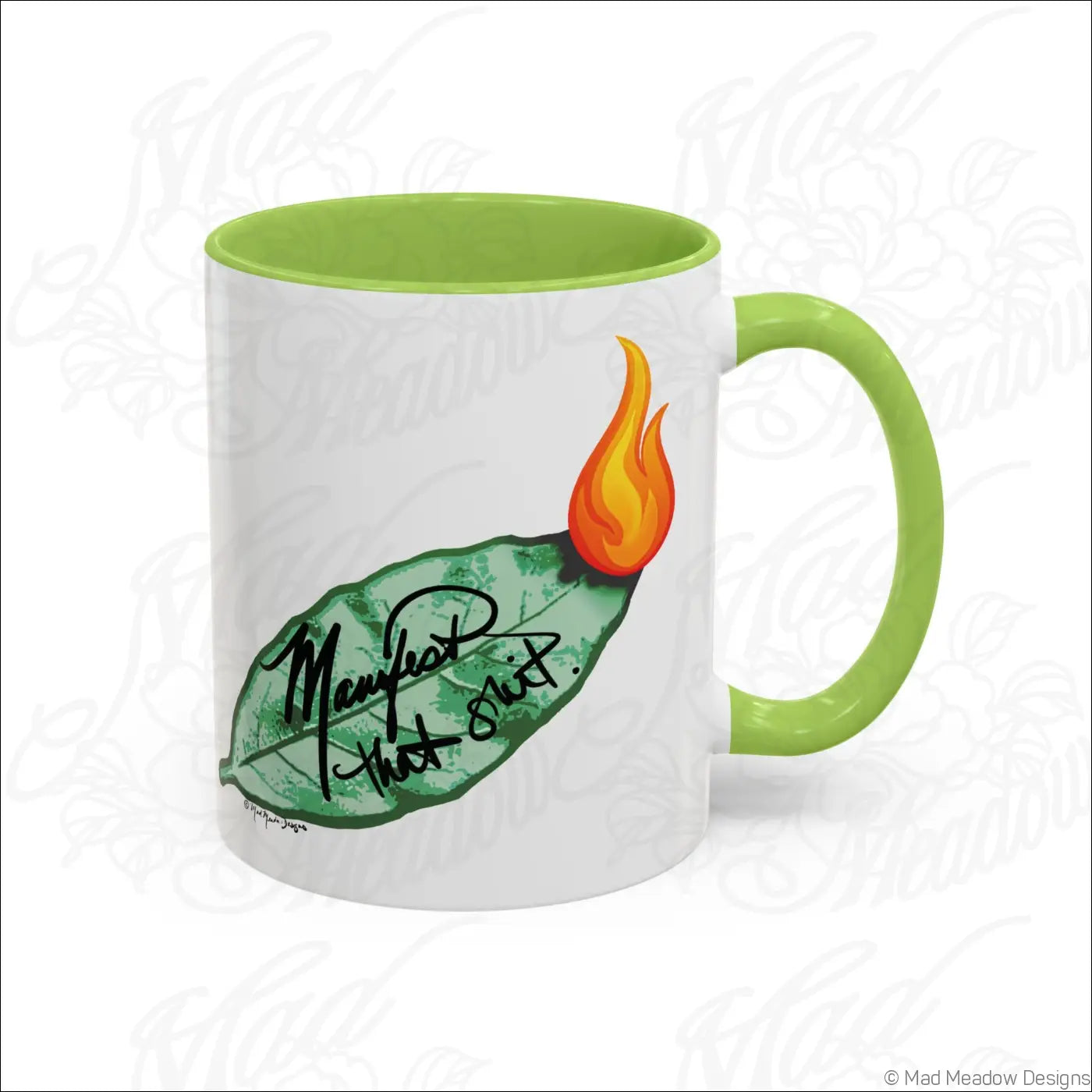 White ceramic coffee mug with glossy finish, lime green colored interior and handle, featuring a burning bay leaf design and manifest that shit text