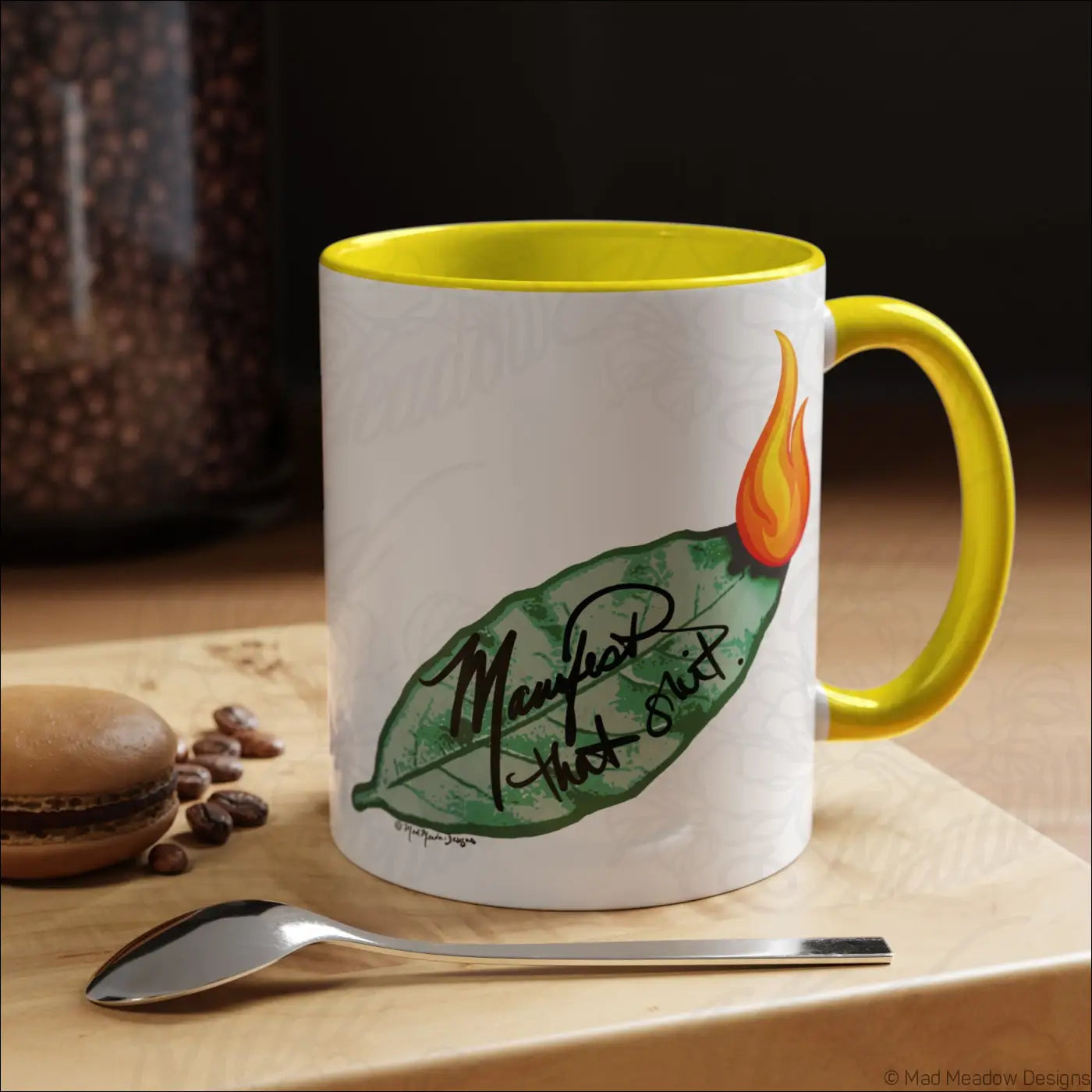 White ceramic coffee mug with glossy finish yellow interior and handle bay leaf and flame design manifest that shit text