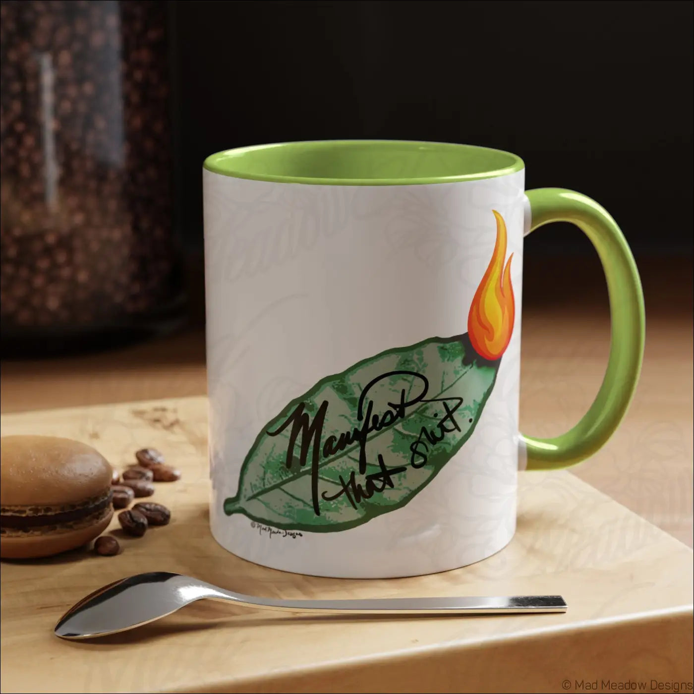 White ceramic mug with glossy finish lime green colored interior and burning bay leaf design manifest that shit script